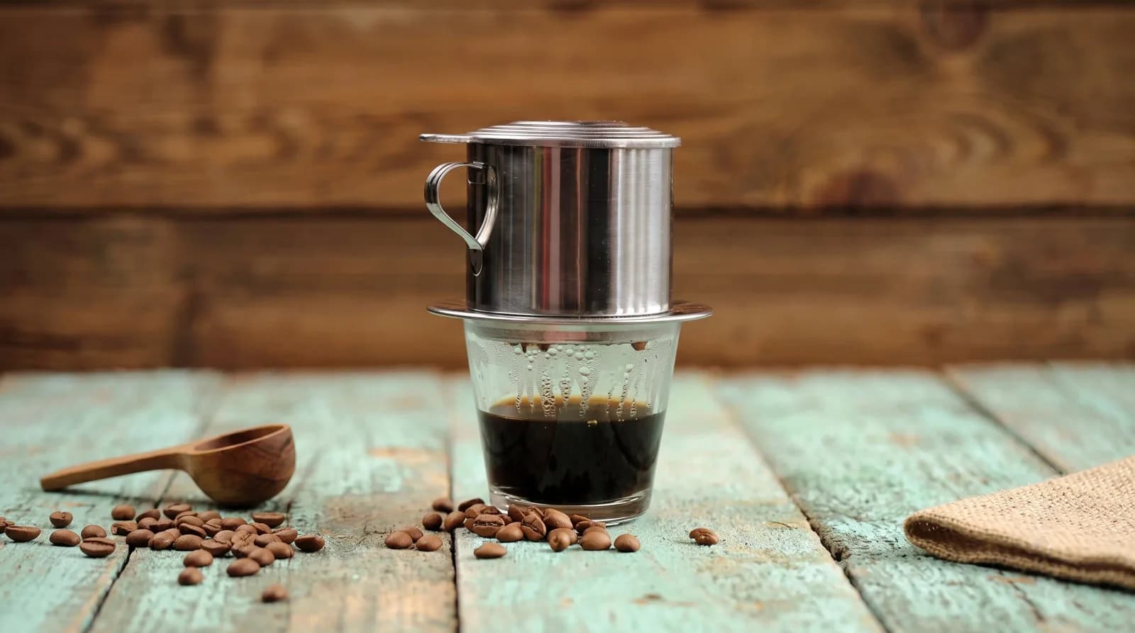 Striped layers of condensed milk and coffee in a glass, ice tower beside.
